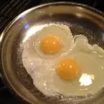 Cracked two eggs in a hot pan brushed with oil